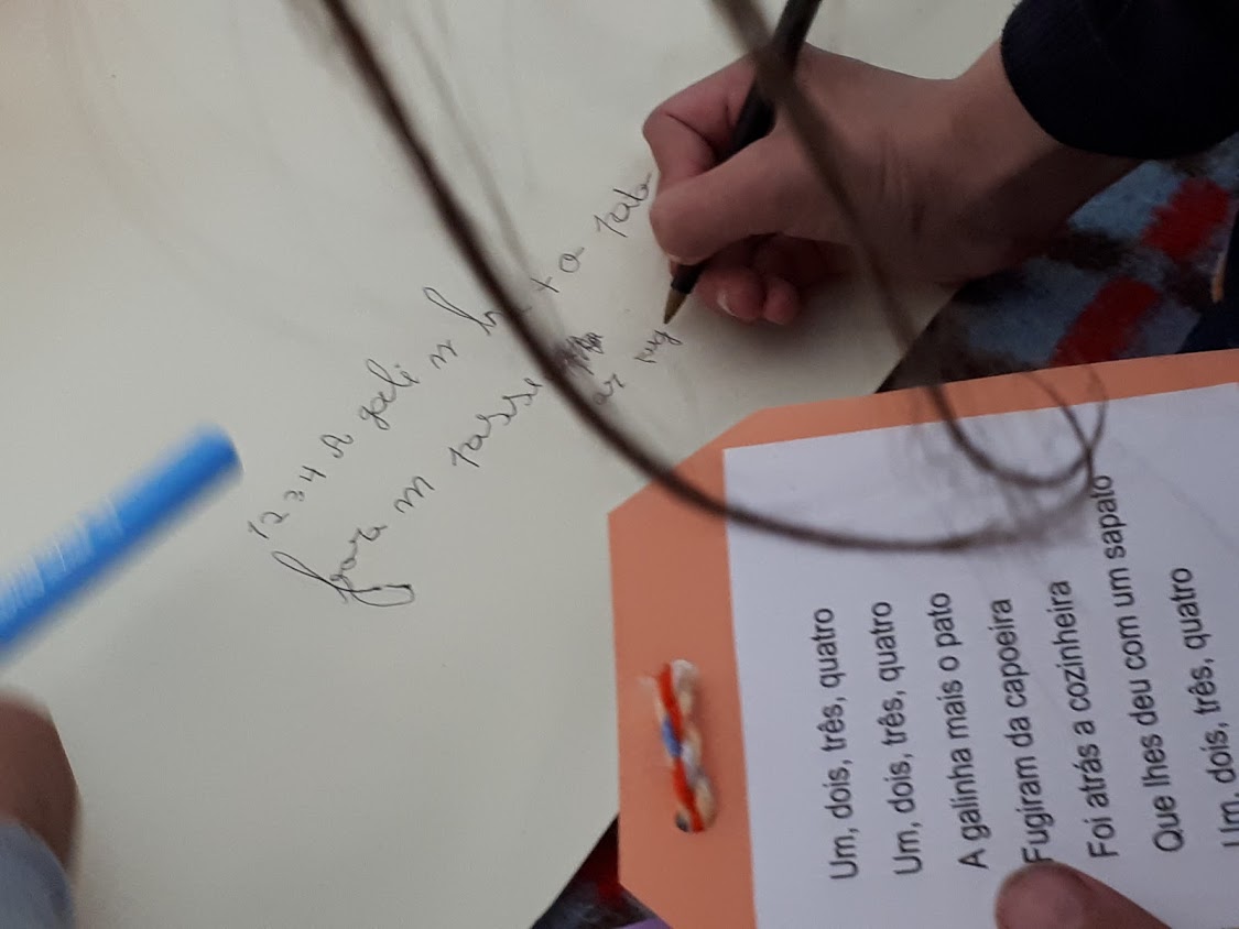 Criança a escrever em folha de papel