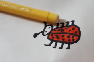 ponta de uma caneta amarela e desenho de uma joaninha