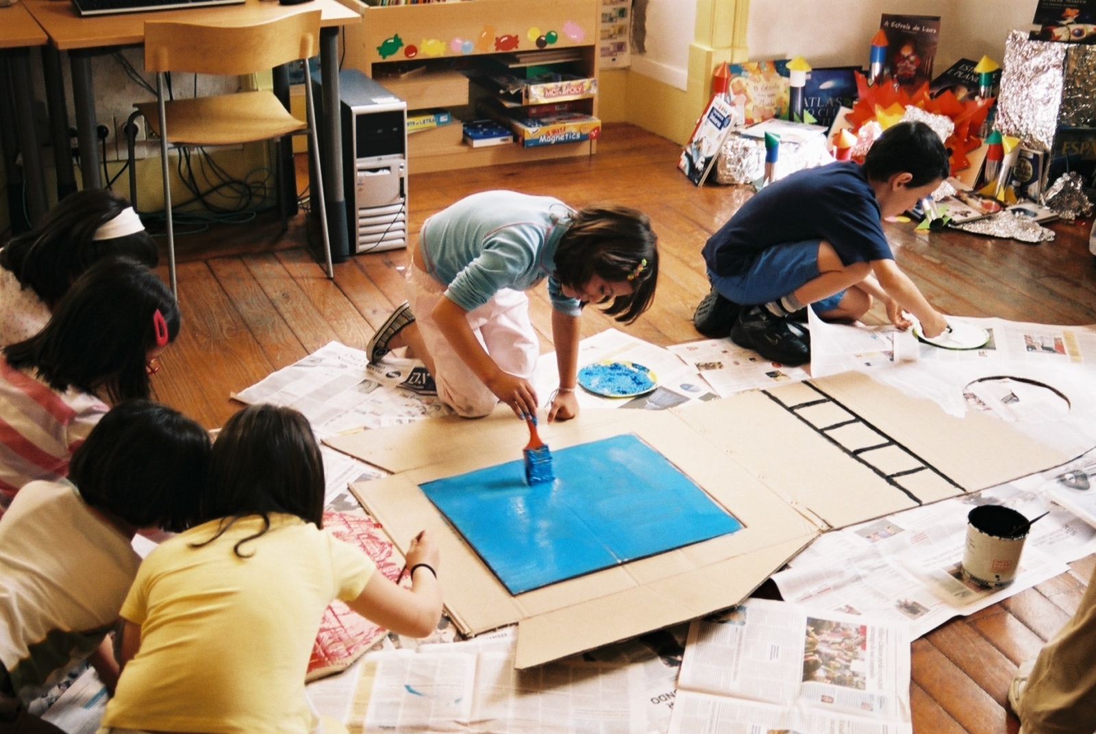 Grupo escolar adesenhar e pintar um foguetão no chão