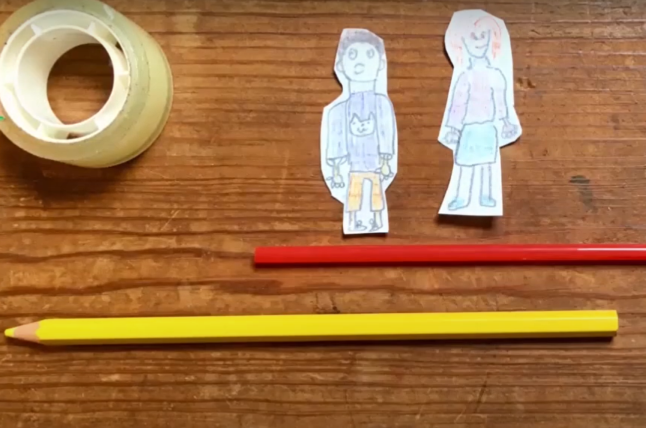 Dois lápis, uma fita cola e dois bonecos desenhados