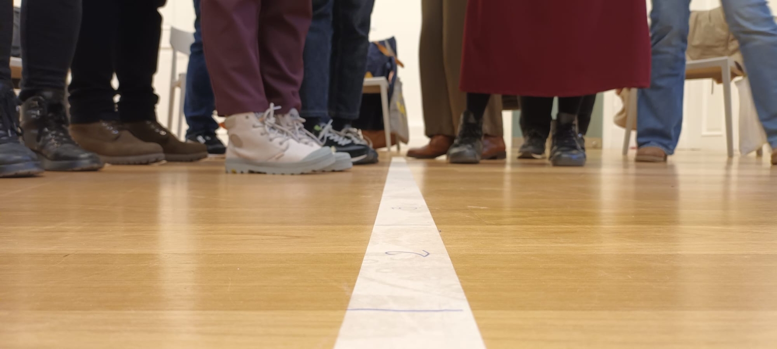 Imagem de pernas e pés de vários participantes numa formação.